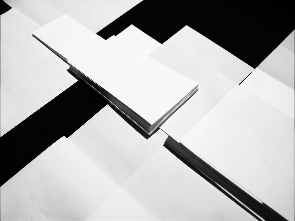 Infotraq Flows: stacked sheets of paper in an abstract composition, in black and white